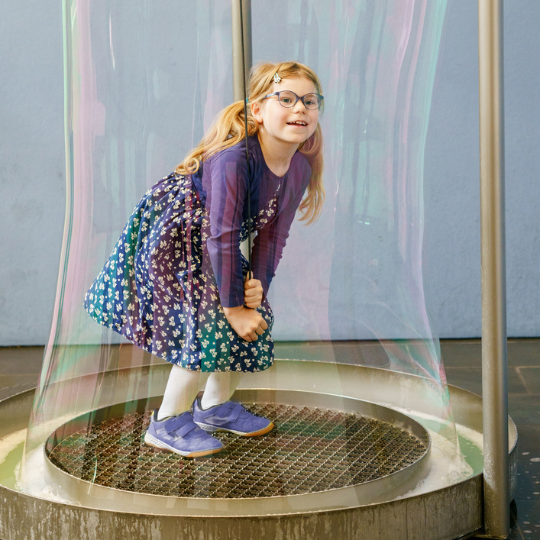 Little girl inside a bubble kids science show